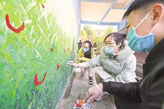 2月8日,在武汉市东西湖区金银湖街花城社区丰泽园小区,志愿者与下沉党员一起为小区架空层彩绘进行后期收尾工作。(湖北日报全媒记者 倪娜 摄)