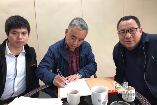 王跃文(中)与胡勇平(右)、刘凯(左)律师签署授权维权委托书。