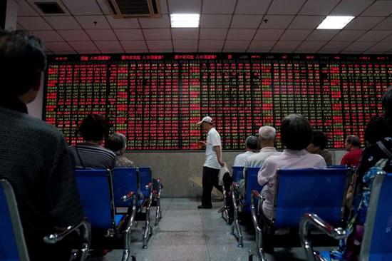 股民6月20日在上海一家证券公司的交易大厅内观看股价信息。（路透社）