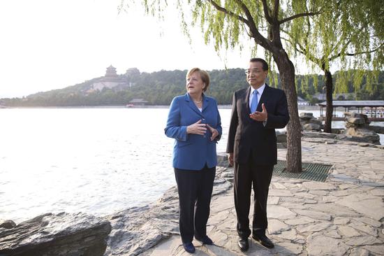 图为2016年6月12日，李克强总理陪同来华访问的德国总理默克尔在颐和园散步。