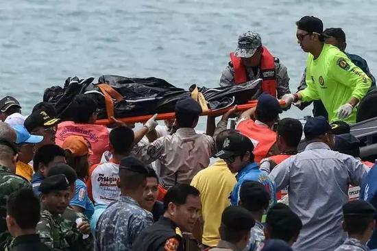 7月6日，在泰国普吉岛差隆码头，救援人员搬运一名遇难者遗体。新华社/法新