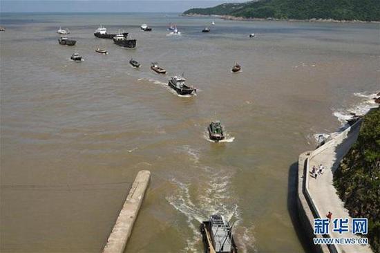 昨天，海上渔船驶入浙江台州市金清大港避风（图片来源：新华网）