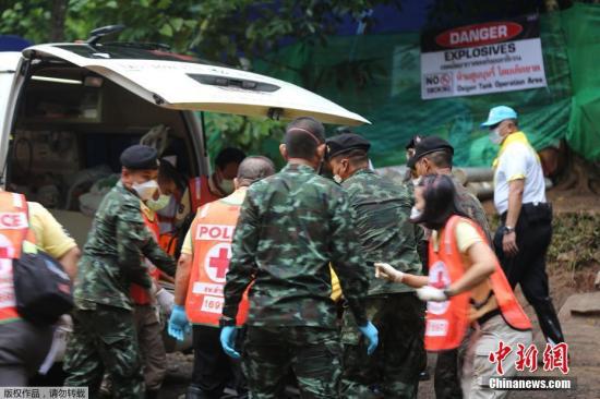 图为7月8日，救援人员将获救少年送上救护车。