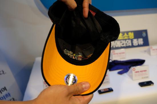 韩国警方展示的新型作案工具——藏在鸭舌帽里的微型摄像头。