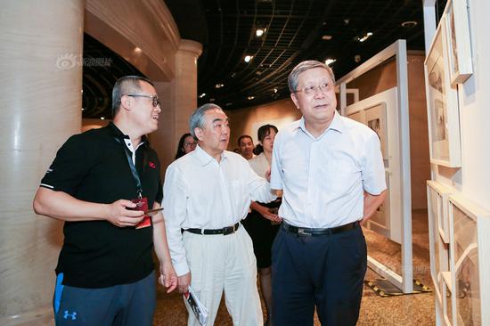 新浪网高级副总裁邓庆旭（左）、中国工商银行原行长杨凯生（中）与中国光大集团前党委书记、董事长唐双宁（右）参观摄影展。
