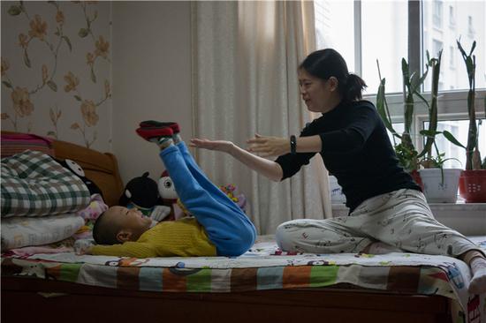 △ 2018年10月15日，北京市通州区，松子妈妈协助松子练习抬腿。
