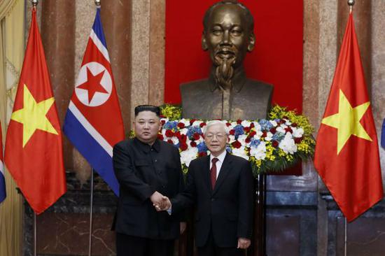 越南国家主席阮富仲(右)与朝鲜国务委员会委员长金正恩3月1日在河内主席府的胡志明塑像前握手。(法新社)