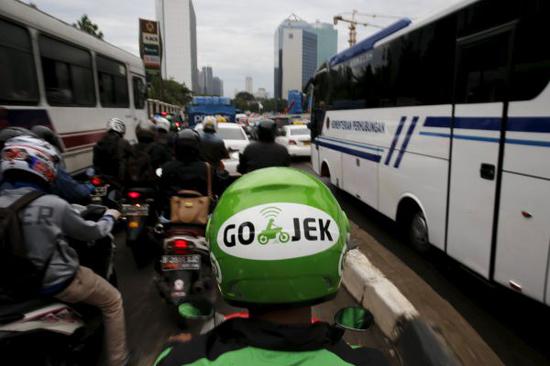 资料图片:印尼首都雅加达,车流中行驶的Go-Jek外卖骑手。(路透社)
