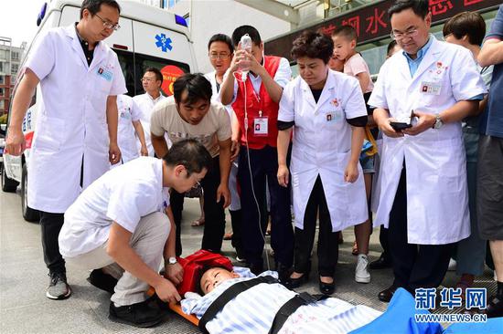 7月26日，在贵州省六盘水市首钢水钢总医院，医护人员准备护送重伤儿童周线胜上救援直升机。新华社记者 杨楹 摄