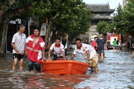8月11日下午，救援人员正在用船将补给品送向被困群众。 新京报记者 王嘉宁 摄