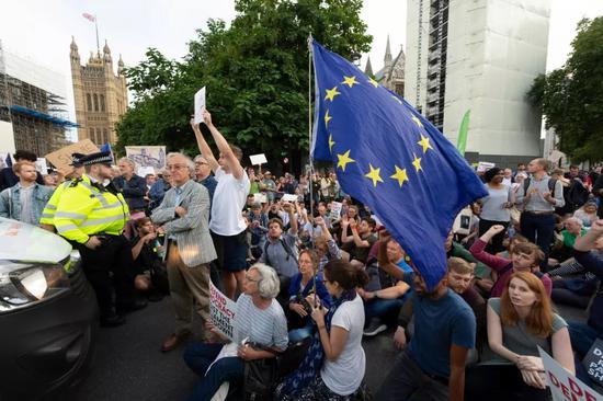 8月28日,在英国伦敦,人们在议会大厦外抗议。新华社发(雷伊·唐摄)