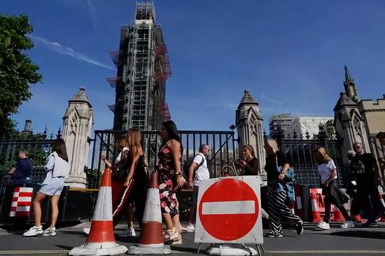 8月30日,在英国伦敦,行人路过议会大厦。新华社/欧洲新闻图片社