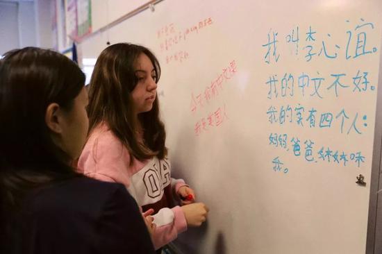 在美国芝加哥，几位学习汉语的佩顿中学学生在黑板上用汉字写句子编故事。新华社记者 汪平摄