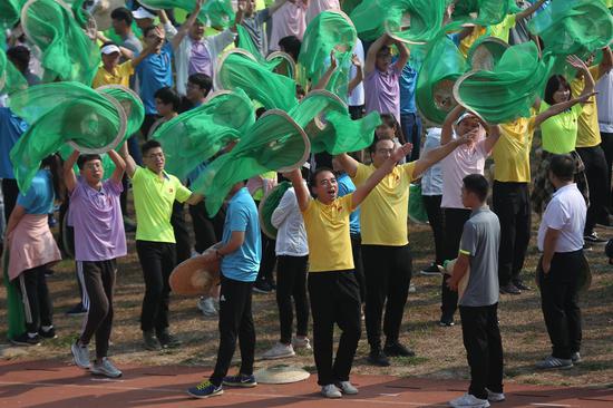 北京科技大学体育场上，2000多名参训人员挥舞着草帽，抖动着帽纱，进行国庆群众游行前的最后集训。摄影/新京报记者 彭子洋