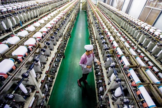2021年10月31日，江苏南通市的一家企业内，工人赶制出口化纤产品订单。图/视觉中国