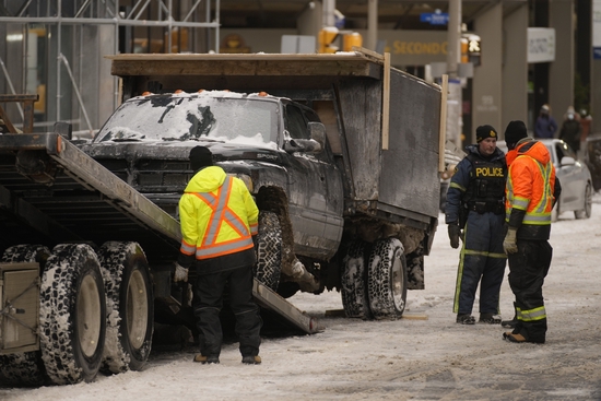 当地时间2月20日，加拿大警方清理渥太华市中心抗议者停放的车辆。图/IC photo