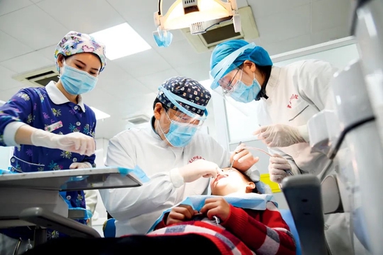 2021年3月3日，陕西西安市，在空军军医大学口腔医院，口腔预防科医生为儿童患者进行口腔诊疗。图/新华