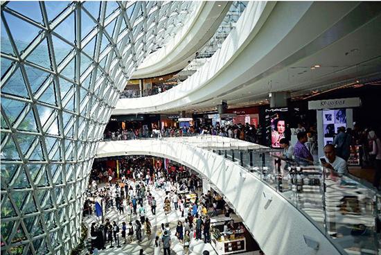 顾客在海南省三亚国际免税城内游览、购物。图/ 新华