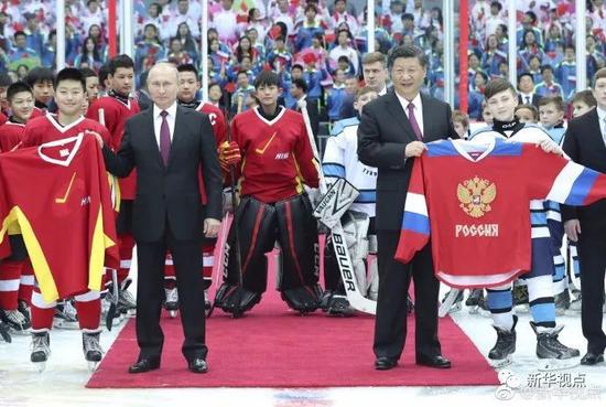 2018年6月8日，习近平同普京在中俄青少年冰球友谊赛前与运动员合影。 新华社记者 庞兴雷摄