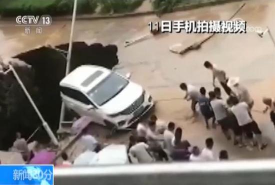 陕西延安暴雨导致路面塌陷汽车悬空 众人拉绳施救