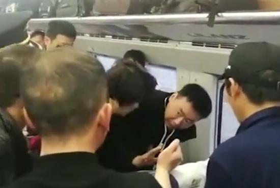 周民在高铁上救助癫痫病患者。    视频截图
