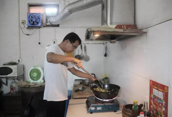 张海超正在厨房里做午饭。新京报记者尹亚飞 摄