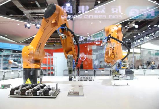 ▲资料图片：2018年11月6日，德国库卡公司的一架协作机器人在进博会的展台上展出。（新华社）