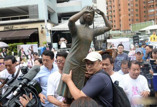 10日，前台北县长周锡玮带领群众呼口号抗议，高举铜像向前推挤