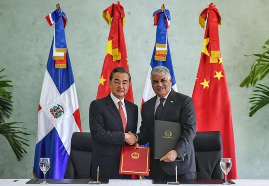 9月21日,在多米尼加首都圣多明各,中国国务委员兼外长王毅(左)同多米尼加外长巴尔加斯签署两国外交部建立政治磋商机制的谅解备忘录。 新华社记者辛悦卫摄