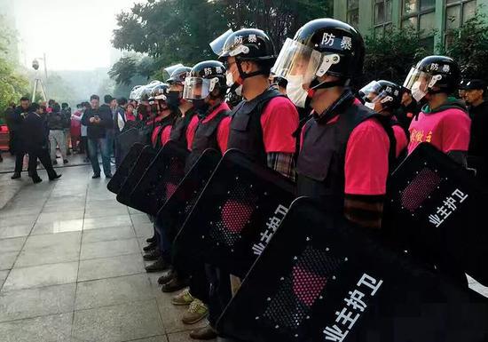 （2016年11月5日，江苏南京市一小区内，众多业主身穿统一服装，带着自买的防刺背心、手套以及盾牌，上面印着“保卫家园、当家做主”。小区业主与物业公司发生冲突的案例屡见不鲜。图/视觉中国）