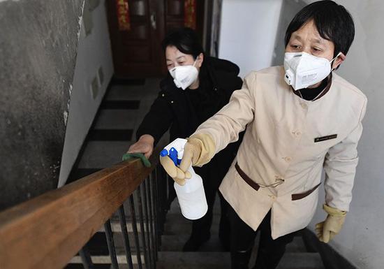 物業服務管理中心的工作人員在對樓道進行消毒。