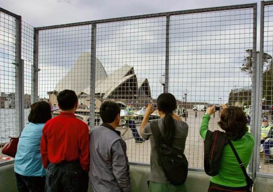 资料图片:中国游客在悉尼歌剧院前拍照。(路透社)