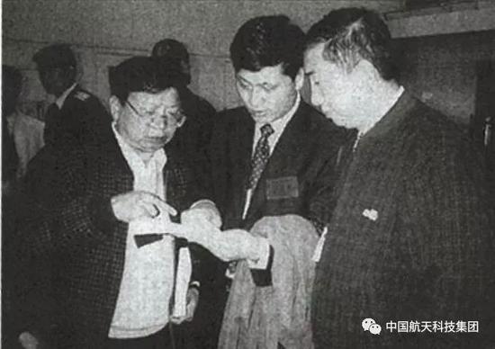 ▲ 2000年10月31日首颗北斗试验卫星发射前，航天科技集团总经理王礼恒（右）、副总经理马兴瑞（中）及卫星总指挥李祖洪（左）一起讨论技术问题
