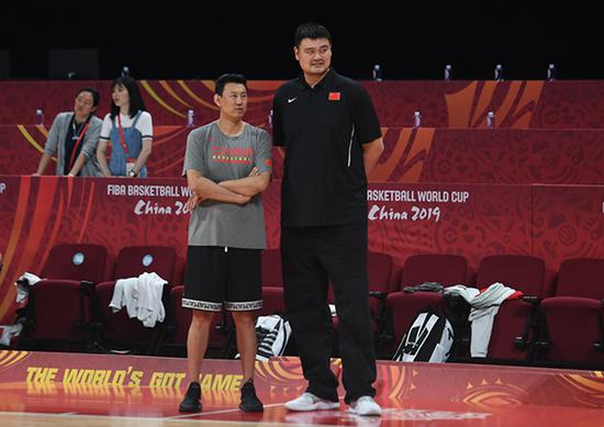 李楠（左）与中国篮协主席姚明在球队训练中交流。 新华社 图