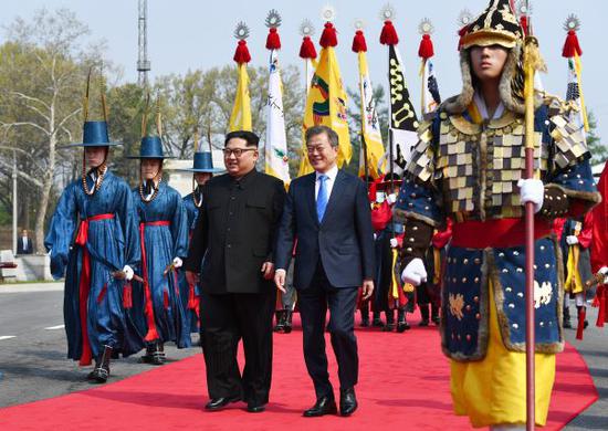 4月27日，朝鲜国务委员会委员长金正恩（中左）与韩国总统文在寅（中右）在板门店出席欢迎仪式。 新华社发（韩朝首脑会晤媒体报道团供图）