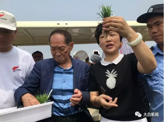 袁隆平向参与“拓荒人计划”的各位嘉宾传递秧苗