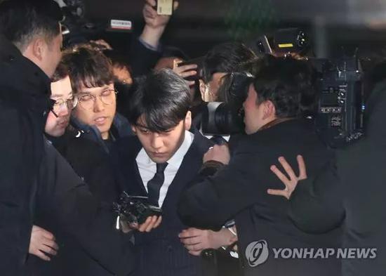 ▲3月15日,李胜利(中)以嫌疑人身份接受警方调查后走出首尔地方警察厅大楼。(韩联社)