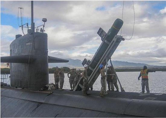 7月3日，在夏威夷珍珠港举行的环太演习中，水兵将一枚“鱼叉”式反舰巡航导弹装入“奥林匹亚”号攻击潜艇。（美国《星条旗报》网站）