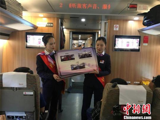 乘务人员为旅客介绍“复兴号”相关知识 张煜欢 摄