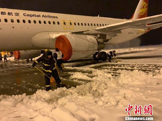 8日晚,大雪纷飞致南京禄口国际机场跑道关闭,机场内在紧张进行扫雪除冰工作。 赵阳 摄