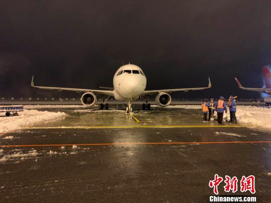 8日晚,大雪纷飞致南京禄口国际机场跑道关闭,机场内在紧张进行扫雪除冰工作。 赵阳 摄