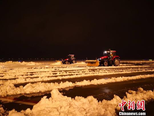8日晚,大雪纷飞致南京禄口国际机场跑道关闭,机场内在紧张进行扫雪除冰工作。 赵阳 摄