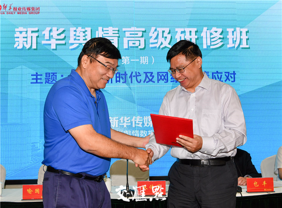 双传学向喻国明颁发新华传媒智库学术委员会主任聘书。肖勇摄