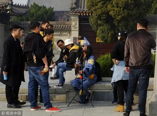 ▲2018年3月,西安一小伙街头扮济公玩直播,吸引众多游客围观。图/视觉中国