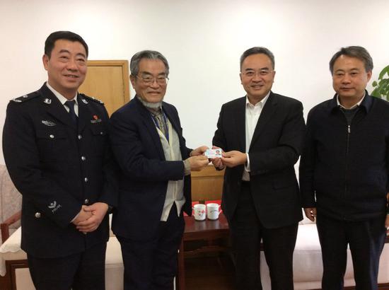 邵子平从南京市人大常委会主任龙翔手中接过大陆身份证,图自大公报