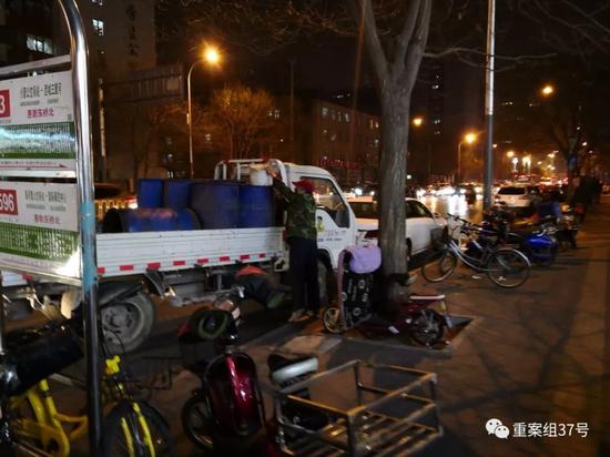 ▲3月22日，朝陽區小營路，一輛泔水車停靠在公交站旁，拉運泔水的人從宏狀元每次搬運兩桶泔水倒入車內泔水桶內。 ? ?新京報記者 王飛 攝