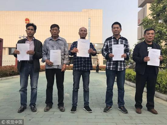 2018年4月11日，安徽省高级人民法院外，安徽涡阳““五周杀人案”五名被告手持无罪判决书。图片来自视觉中国