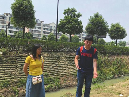 廖圳龙重返施救现场,其身后便是老人溺水的排水渠。