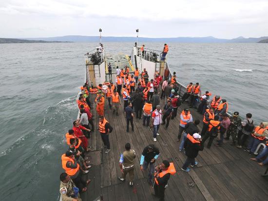 6月19日，在印度尼西亚北苏门答腊省，救援人员乘船参与搜救。（新华/美联）