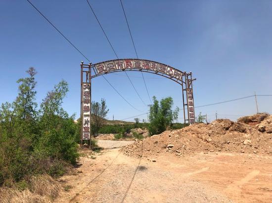 5月22日,爱心村后门的路已经被土堵住,牌坊破旧不堪。新京报记者王翀鹏程摄